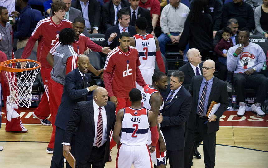 Coaches and players talking on the sideline of an NBA game